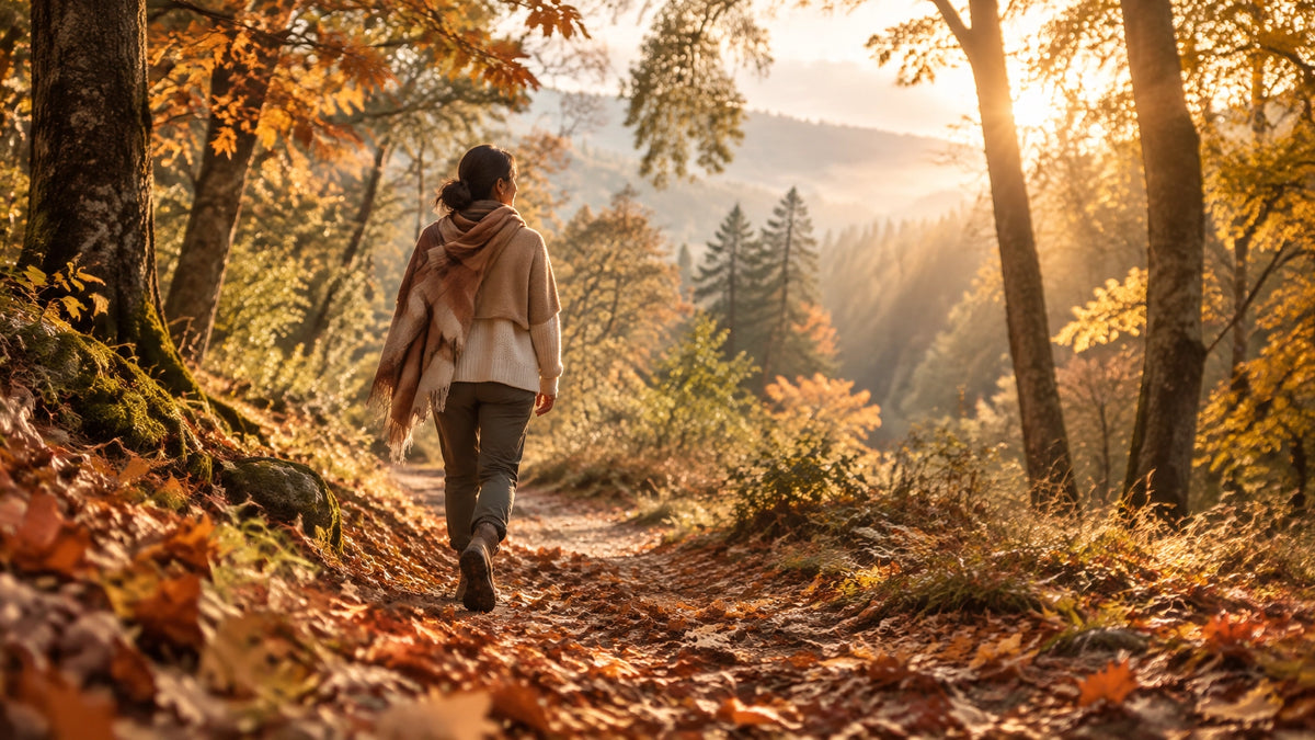 Bosque mexicano en otoño con hojas ocres, luz dorada y una persona caminando con ropa en capas